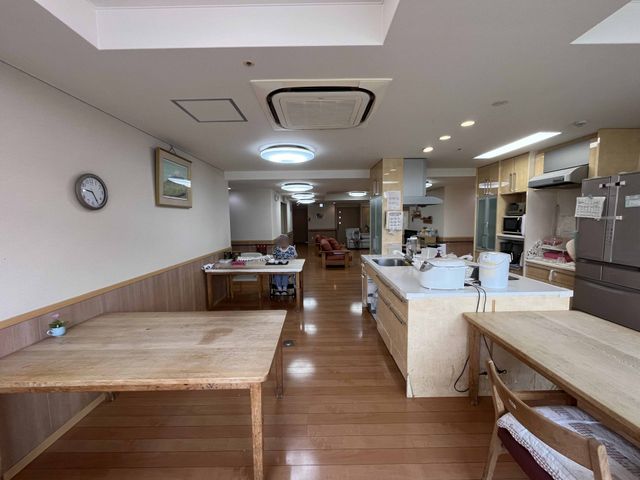キッチン周辺の空間 キッチン 広々とした空間に木製テーブルが配置され、自然光が差し込む明るいキッチンです。アットホームな雰囲気で、心地よい時間を過ごせます。