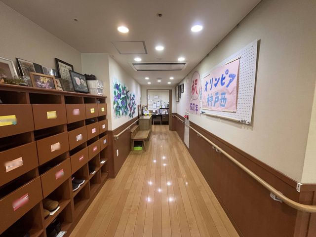 温かみのある廊下 廊下 温かみのある色合いと明るい照明が施された廊下です。職員と利用者の活気にあふれています。