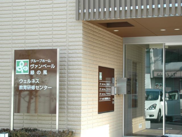看板があるエントランス 外観２ 清潔感が漂う入口には分かりやすい案内看板が設置されており、訪れる方を暖かく迎え入れています。