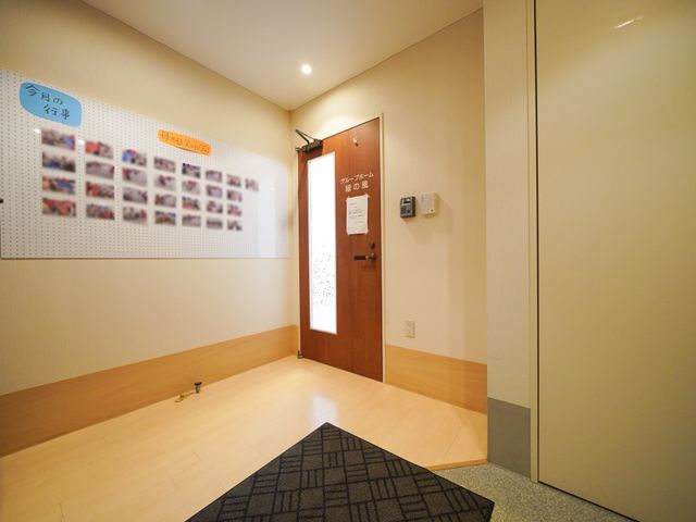 廊下の掲示物とドア 掲示物 掲示板には様々な情報がびっしりと掲示されており、その横には入室を許可された方のみが入れる安心のドアがあります。