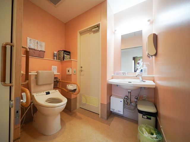 バリアフリー設計のトイレ トイレ 手すり付きで安全性に配慮したトイレです。広々とした洗面スペースも備え、利用者の快適さを考えた造りになっています。