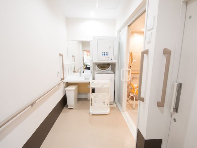 清潔感のある洗濯室 洗面台 手すりが設けられた洋室の洗濯室です。洗濯から乾燥まで、入居者の日常生活を支えます。