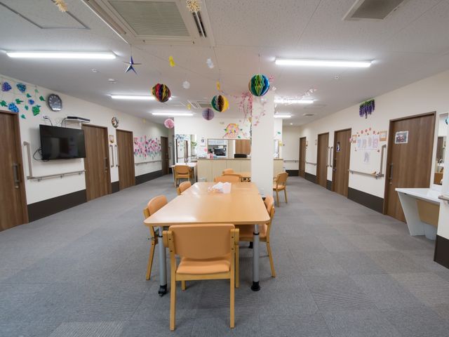 装飾された広々とした空間 談話室 天井からの飾り付けが目を引く開放感のあるラウンジです。テーブルを囲みながら、楽しいひと時を過ごすことができます。