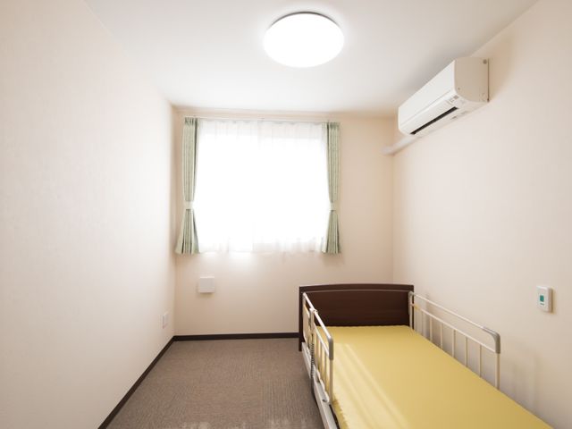 清潔な個室の居室 居室 ゆったりとしたベッドと暖かい陽光が差し込む居室です。プライベートな空間を大切にされたい方に適しています。
