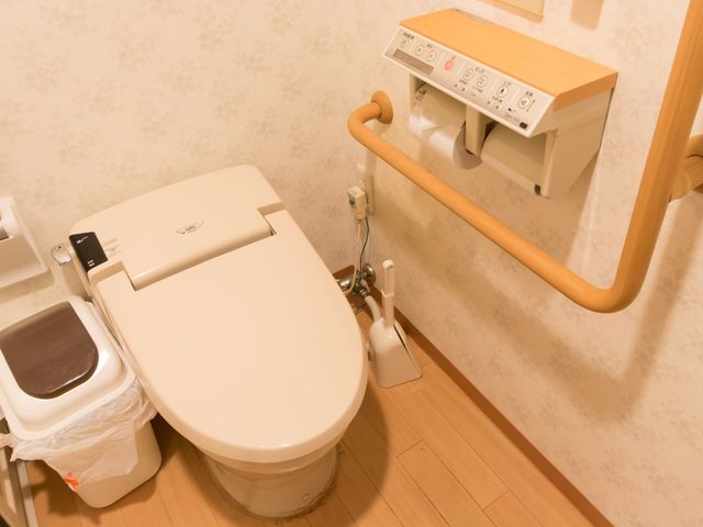 バリアフリー設計のトイレ トイレ 手すり付きで座りやすいトイレは、利用者の安全性を考慮した設計です。清潔感のある空間が確保されています。