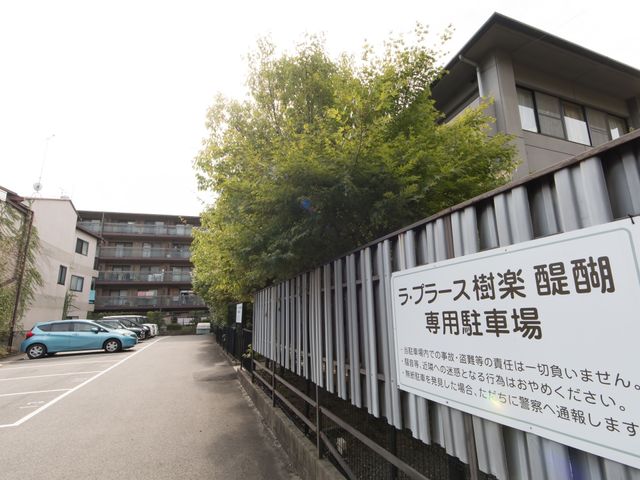 木々に囲まれた建物外観 駐車場 静かな住宅街に位置し、落ち着いた雰囲気の建物が目に留まります。澄み切った空気と緑豊かな環境が、日々の業務に安らぎを与えてくれそうです。