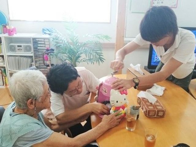 スタッフと利用者のふれあい 温かな雰囲気の中でスタッフが利用者の方々とコミュニケーションを取っています。ここでは笑顔で日々の支援が行われています。