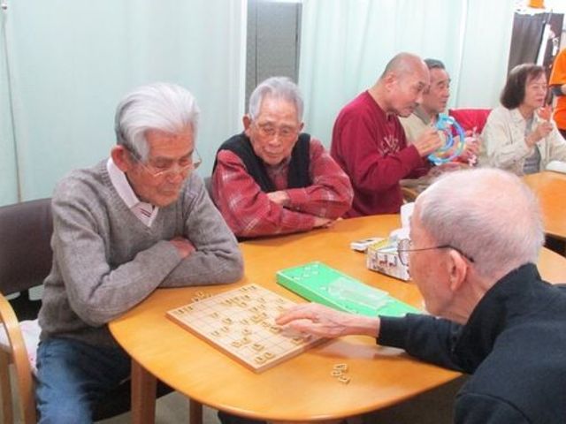 多世代が楽しむレクリエーション みなさんで集まってボードゲームに興じる和気あいあいとした空間です。日々の生活に潤いをもたらす場がここにあります。
