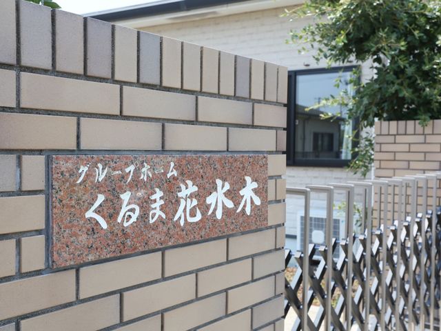 施設の看板と外観 建物外観 施設の入り口に掲げられた看板が、訪れる人を温かく迎えます。外から見ても落ち着いた雰囲気が伝わり、訪問者に安心感を与える造りになっています。