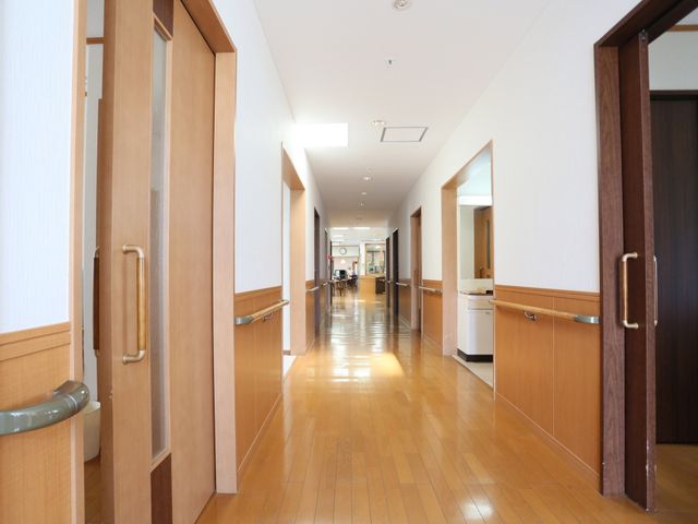 木目調の温かみある廊下 廊下 広々とした清潔感のある通路です。壁には手すりも完備され、安全に配慮された設計となっております。