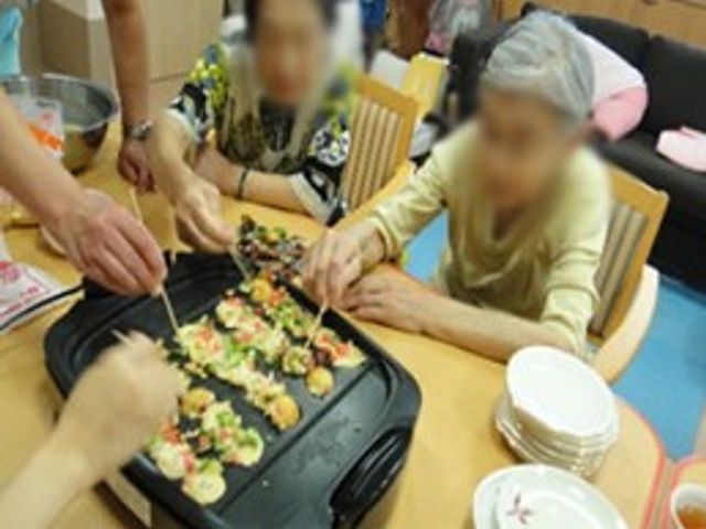 たこ焼きを作る様子 ダイニングルーム 温かみのある空間で、一緒にたこ焼きを作りながら交流を楽しめます。料理を通じたコミュニケーションの場として最適です。