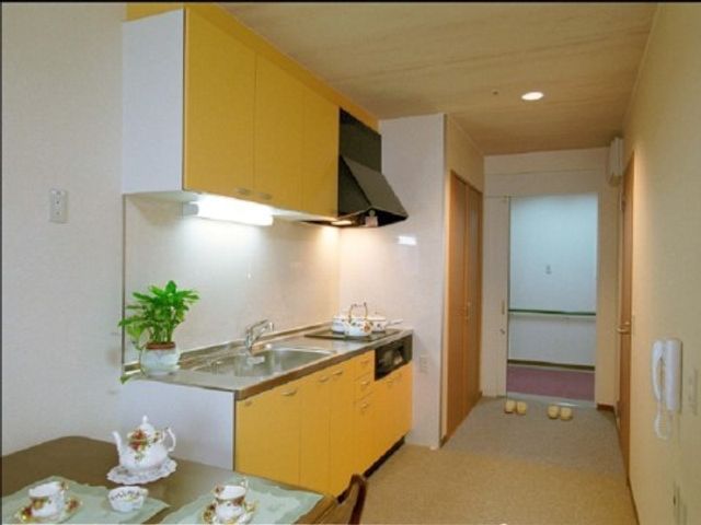 清潔なキッチン付き居室 居室・キッチン 自然光が差し込む居室で、快適なキッチンが備わっており、自立した日常生活をサポートしています。