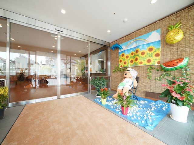 明るいエントランスの様子 玄関 開放的な空間のエントランスには、元気なディスプレイが設置されており、明るい気持ちでお出迎えいたします。
