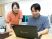 スタッフがPCで確認する事務室  