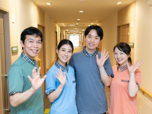 笑顔のスタッフが廊下で挨拶する様子  
