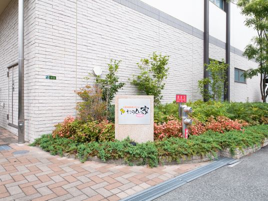 白い壁の建物と緑の庭