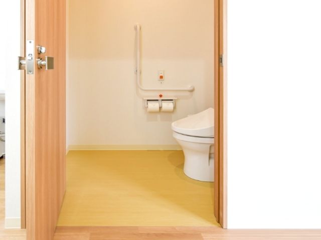 使いやすいトイレ トイレ 手すりが設置された明るいトイレは、利用者の安全を考慮したデザインです。