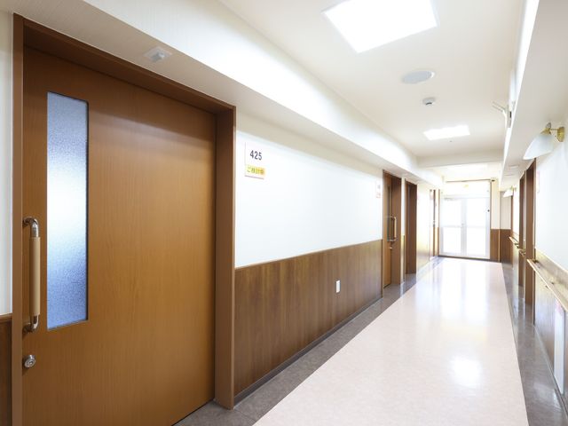 明るい廊下の光景 廊下 広々とした通路は清潔感があり、明るい日差しが心地よい空間を創出しています。