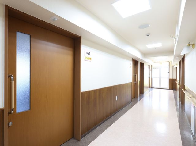 明るい廊下の光景 廊下 広々とした通路は清潔感があり、明るい日差しが心地よい空間を創出しています。