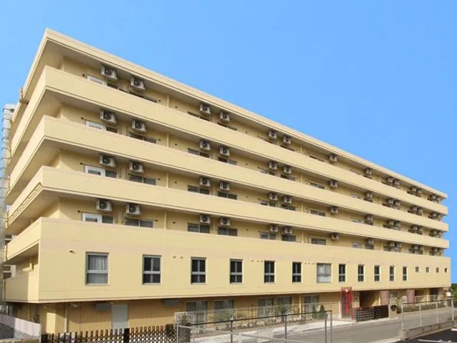 建物外観 外観   明るいベージュ色の大きな建物で、各階にベランダが並んでいます。就業先の雰囲気をつかみやすい外観です。