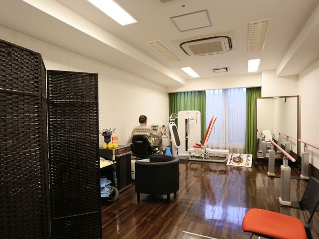 明るく広々とした機能訓練室 ジム 柔らかな光が差し込む機能訓練室です。適切な器具が整い、利用者が積極的に身体を動かす姿が見受けられます。