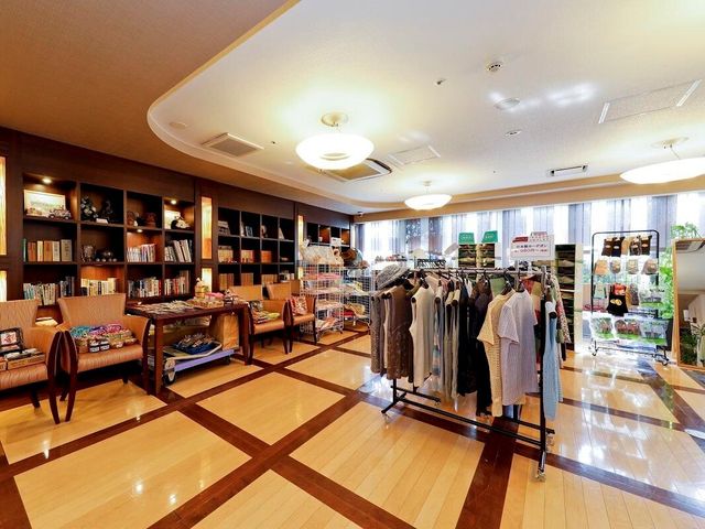 共有ラウンジと物販スペース エントランスホール 本棚に囲まれたラウンジは、読書やくつろぎのひとときをご提供します。物販スペースも充実しており、日用品が手軽に手に入ります。