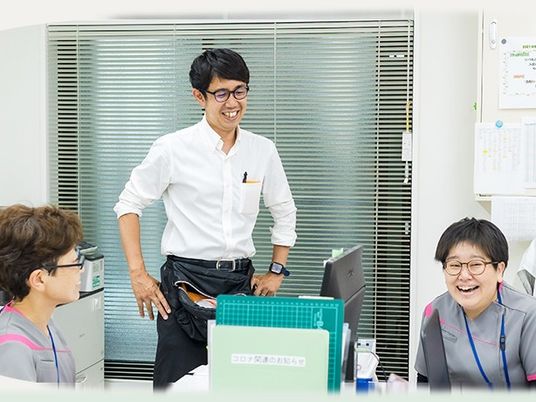 スタッフが談笑する事務室  