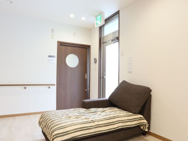 明るい居室の一角 休憩スペース ゆったりとした床面積の居室です。心地よい素材のベッドで、安らかな休息を提供しております。