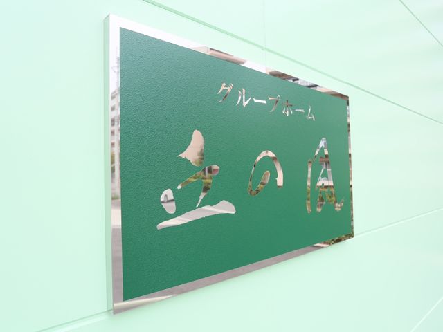 緑色の施設看板 看板 エレガントなデザインの看板が訪れる人を温かく迎え入れます。ここで働くことは、毎日が充実することでしょう。