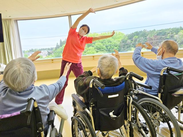 体操指導の様子 機能訓練室 広々とした空間で、スタッフの指導のもと体操が行われています。自然を感じながらの運動が可能です。