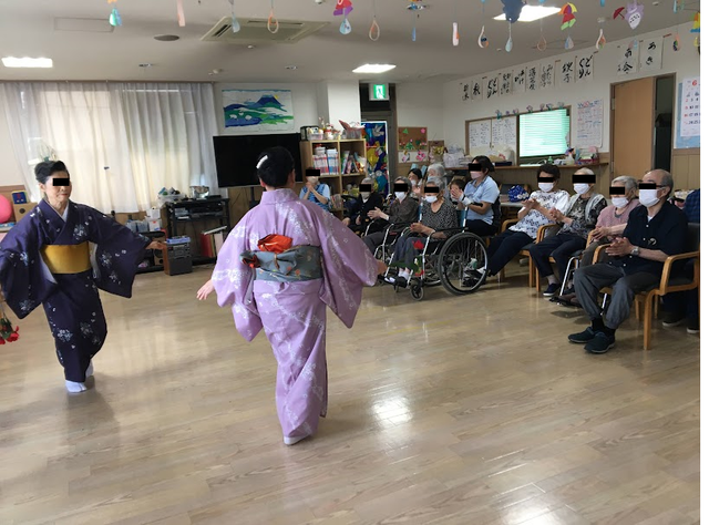 舞踊イベントのリビング リビング 広々としたリビングで着物姿のダンスが披露されています。車椅子の方も楽しまれています。