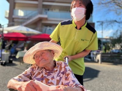 屋外で笑顔の介助者と利用者