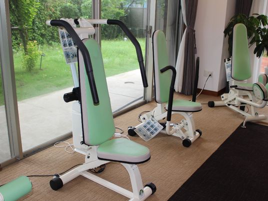 トレーニングルームの角部分に置かれているマシンである。クッション性のある椅子に座った体勢で運動を行うことができる。