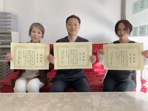 表彰状を持つ3人のスタッフ  