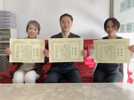 表彰状を持つ3人のスタッフ  