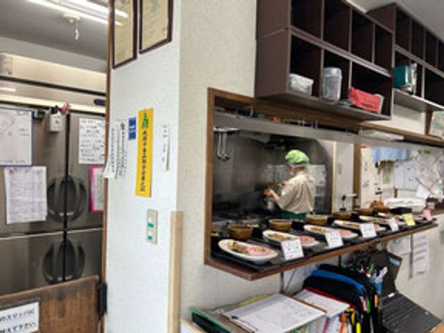 調理中の厨房 キッチン 活気あるキッチンは、スタッフが丁寧に料理を準備しています。色とりどりのメニューが並び、温かみを感じます。