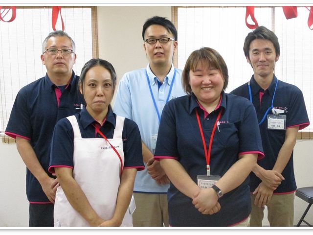 スタッフ集合のスタッフイメージ スタッフイメージ   5人のスタッフが並んで立っており、落ち着いた表情の方や笑顔の方がいます。明るい雰囲気で、チームで働く様子が伝わります。