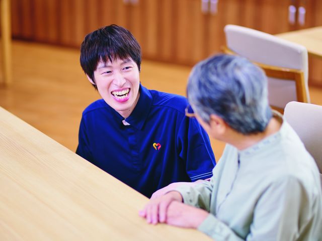 和やかな対話の場 ラウンジ 明るい空間での会話が楽しめる、スタッフと利用者の親しみやすい交流の様子です。