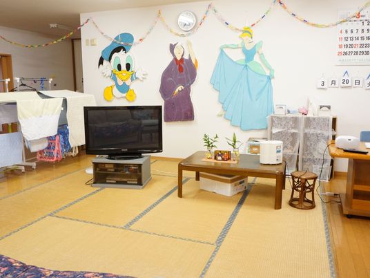 畳を敷いたスペースの奥の壁には大きなキャラクターの飾りが飾られている。テレビがあるので、大勢で楽しむことができる