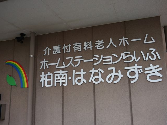 虹とりんごの看板デザイン ロゴ 明るく楽しい印象を与える虹とりんごのデザインが目を引くエントランスです。お越しの際は温かい雰囲気にご注目ください。