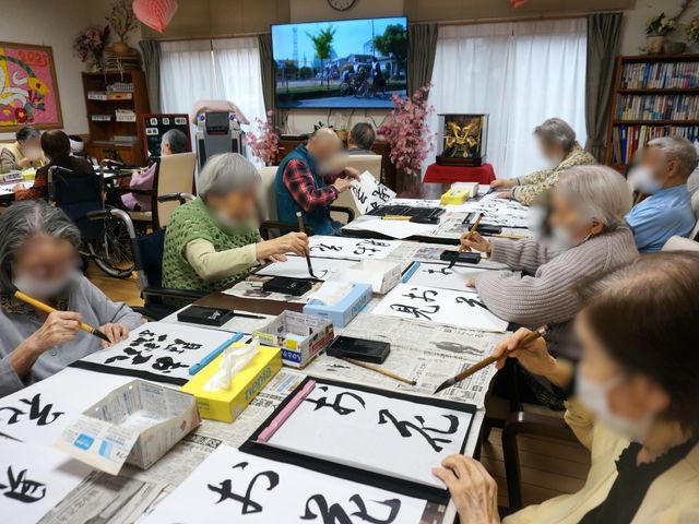 活動支援の多目的室 クラブ活動（習字） 多様なレクリエーションを支えるやりがいある勤務環境。利用者の方々の生活を豊かにするお手伝いができます。