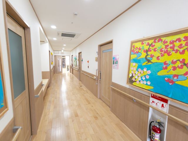 掲示物飾る廊下の風景 廊下 清潔感あふれる廊下には色とりどりの絵画が展示され、訪れる人々に潤いを提供しています。