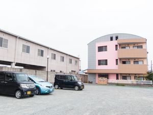 ピンクの建物と駐車場
