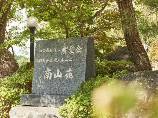緑に囲まれた施設の看板  