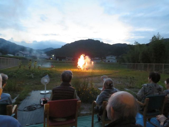 夕暮れ時の中庭イベント イベント風景 夕暮れが訪れる中庭で、イベントを楽しむ方々の和やかな雰囲気が漂っています。共に過ごす時間の大切さを感じられる場です。
