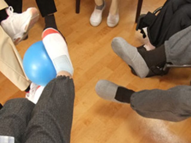 リハビリの様子 機能訓練室 みんなでボールを使ったリハビリを楽しんでいます。和やかな雰囲気が広がっています。