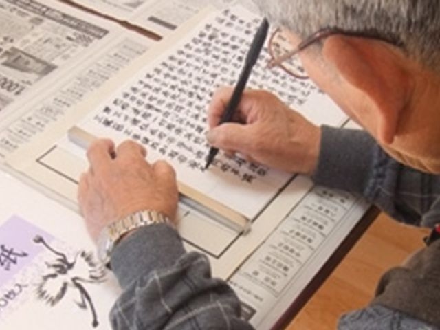 書道を楽しむ男性 多目的室 明るい空間で書道を楽しむ姿です。ゆとりある環境が整っています。
