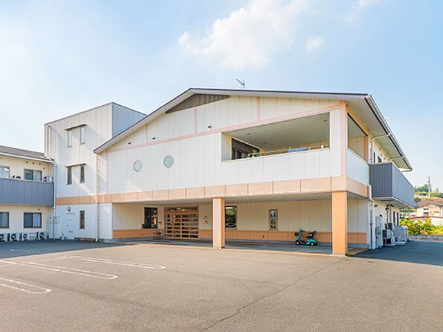白い壁の建物 外観 白を基調とした開放的な建物です。明るい空の下、清潔感が漂います。