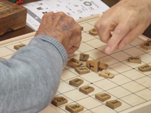 手を使った活動 スタッフイメージ 利用者が将棋を楽しむ様子です。手を使った活動は交流と脳の活性化に役立ちます。