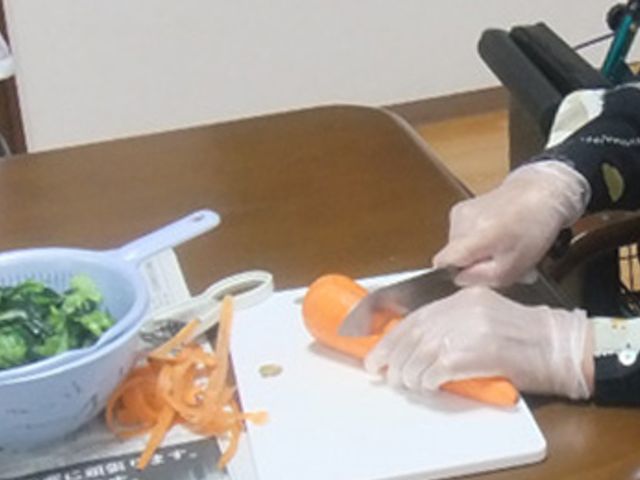 調理をしている手元 ダイニングルーム 明るいダイニングルームで、調理を楽しむ入居者の様子が見られます。